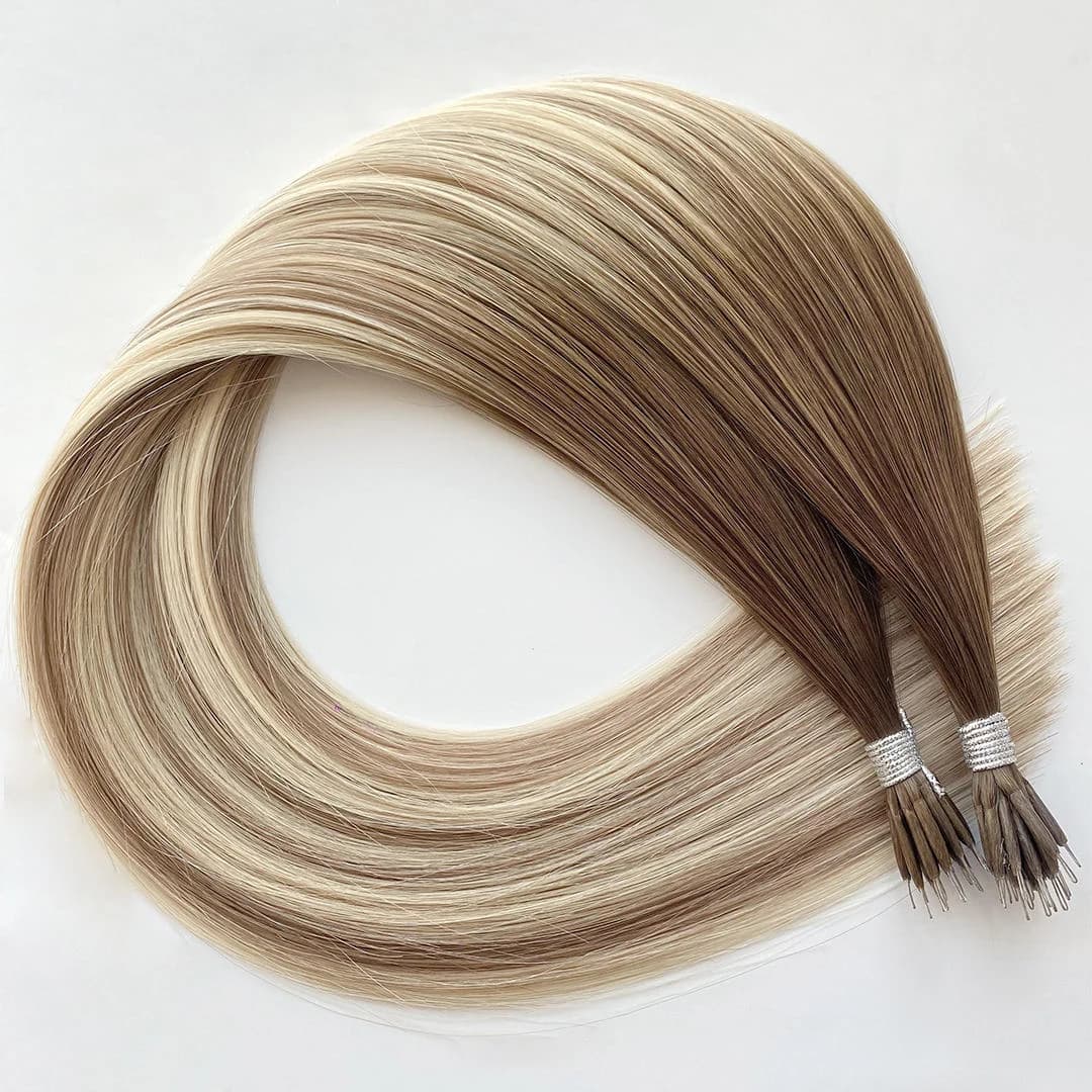 Rooted blonde nano ring hair extension bundles arranged in a loop on a white surface