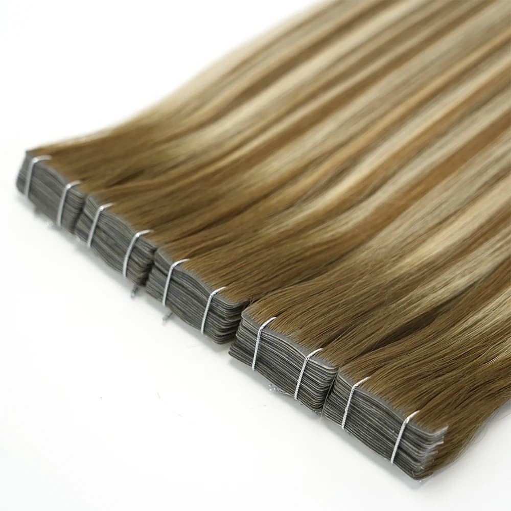Rooted blonde tape-in bundles with stacked attachment edges arranged diagonally on white