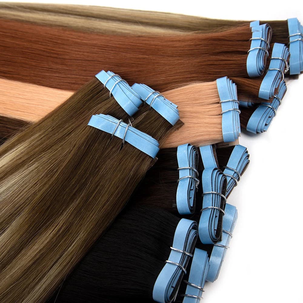 Tape-in bundles in dark, brown and warm shades with blue protective backing and ties visible