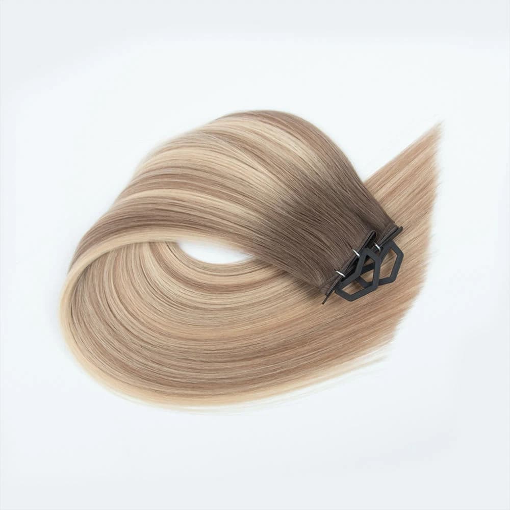 Rooted blonde hair extension sample arranged in a loop with black display clips