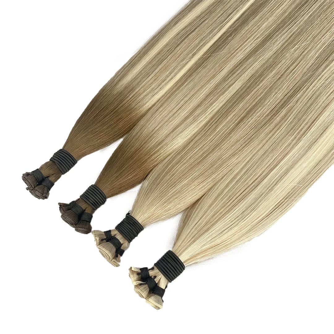 Dimensional blonde weft bundles with tied rolled seams on a white background
