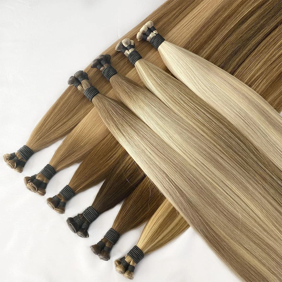 A mixed range of brown and blonde weft bundles arranged across a white surface