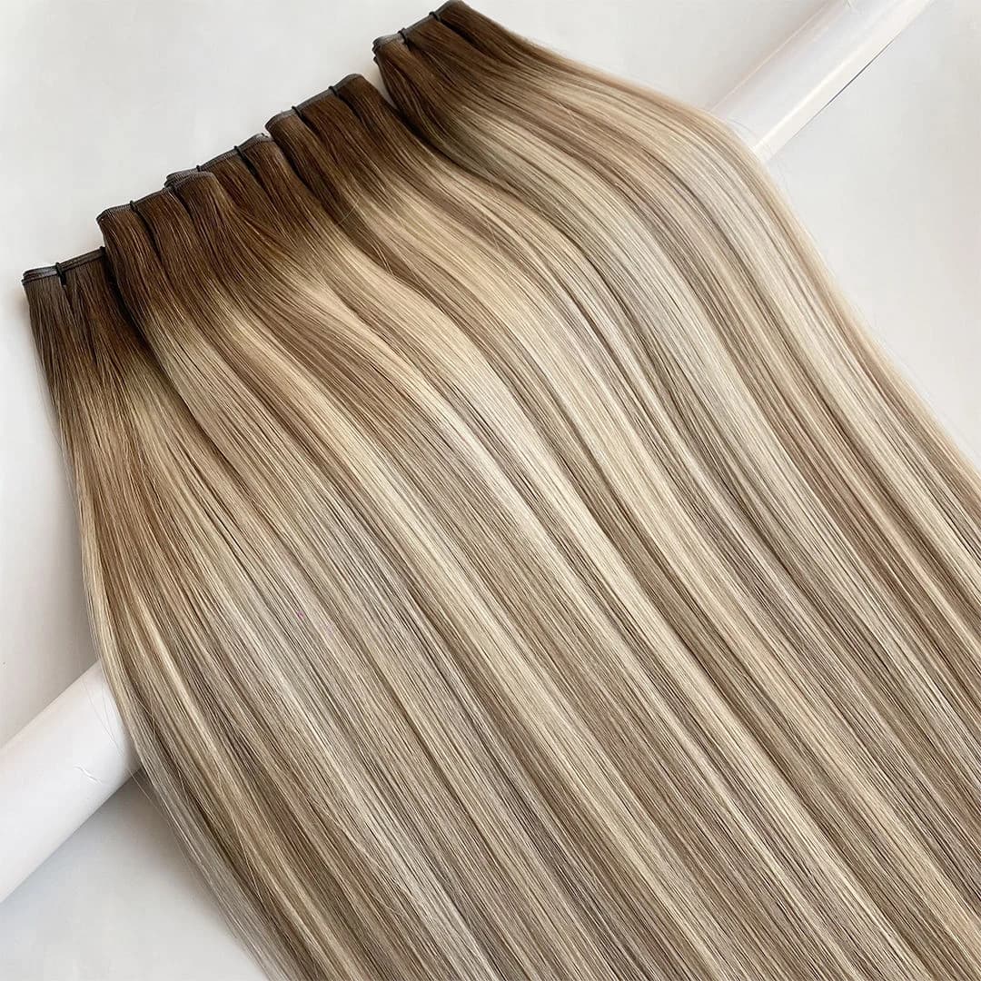 Rooted blonde wefts laid open with narrow dark sewn edges visible
